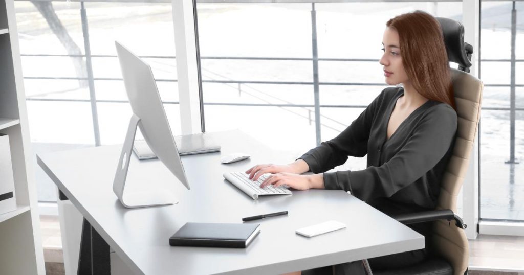 Person sitting with aligned posture while working at a computer